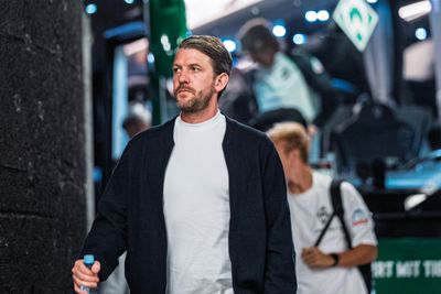 Peter Niemeyer mit einer Flasche in der Hand, im Hintergrund der Mannschaftsbus.