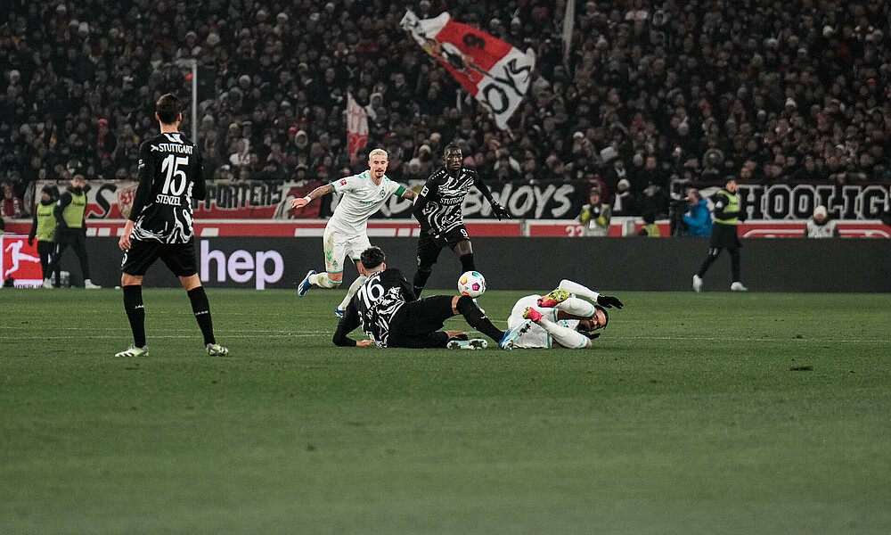 Marco Friedl im Duell mit Guirassy, davor zwei Spieler, die am Boden liegen. 
