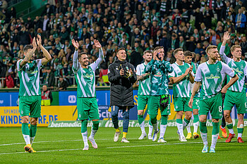 Leonardo Bittencourt und weitere Werder-Spieler stehen in einer Reihe und klatschen.