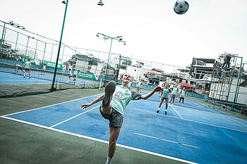 Reena Wichmann versucht beim Fußballtennis den Ball rückwärts über das Netz zu spielen. 
