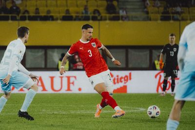 Marco Friedl spielt einen Pass und trägt dabei das Nationaltrikot.