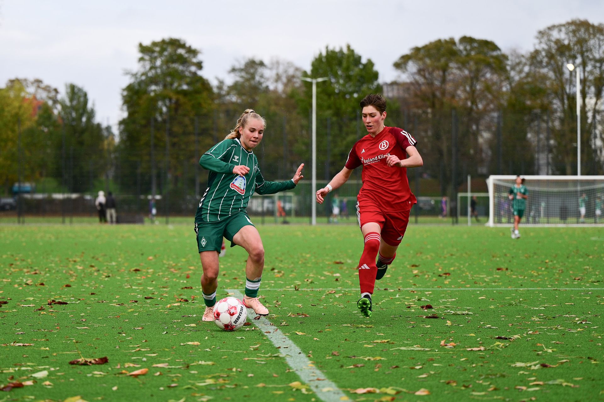 Eine Spielerin der 2. Frauen im Heimtrikot mit dem Ball aus.