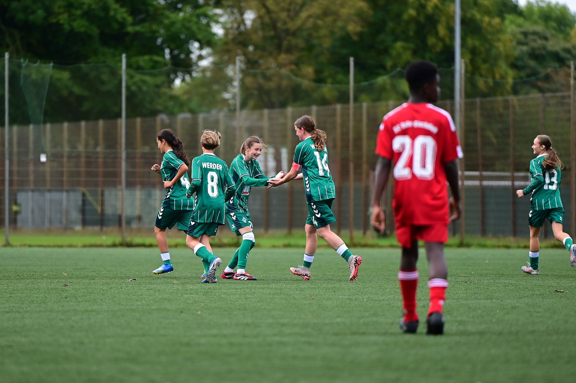 Die Werder U15-Spielerinnen feiern nach einem Tor und klatschen sich ab.