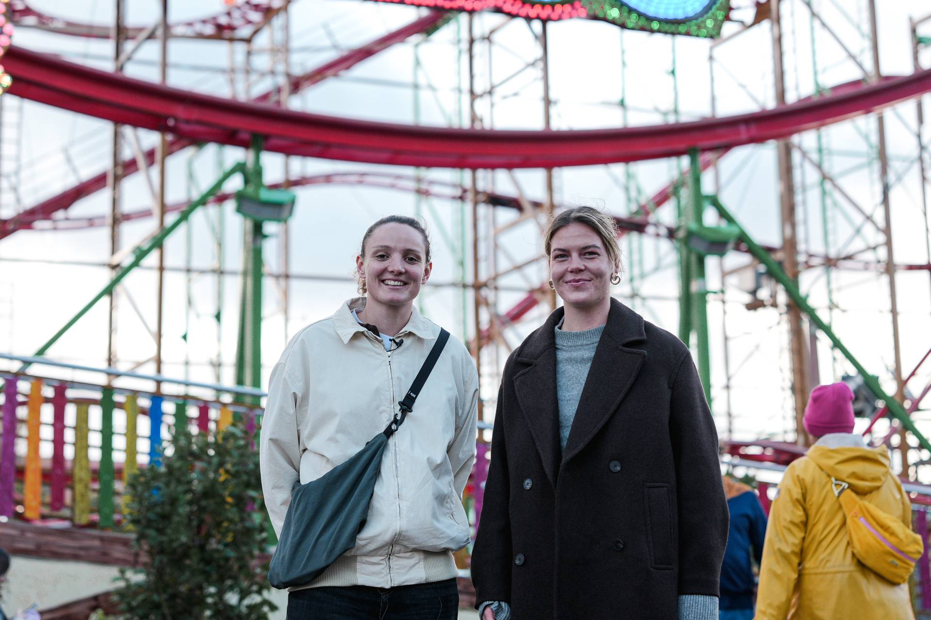 Verena Wieder und Juliane Wirtz stehen vor einer Achterbahn.