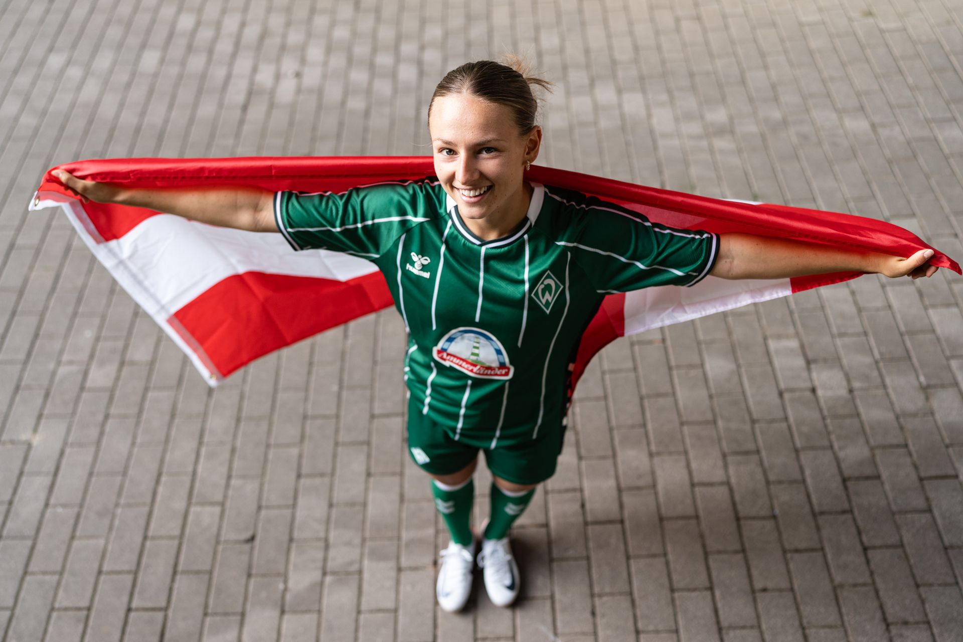 Chiara D'Angelo im Werder-Trikot mit einer großen Österreich-Fahne.