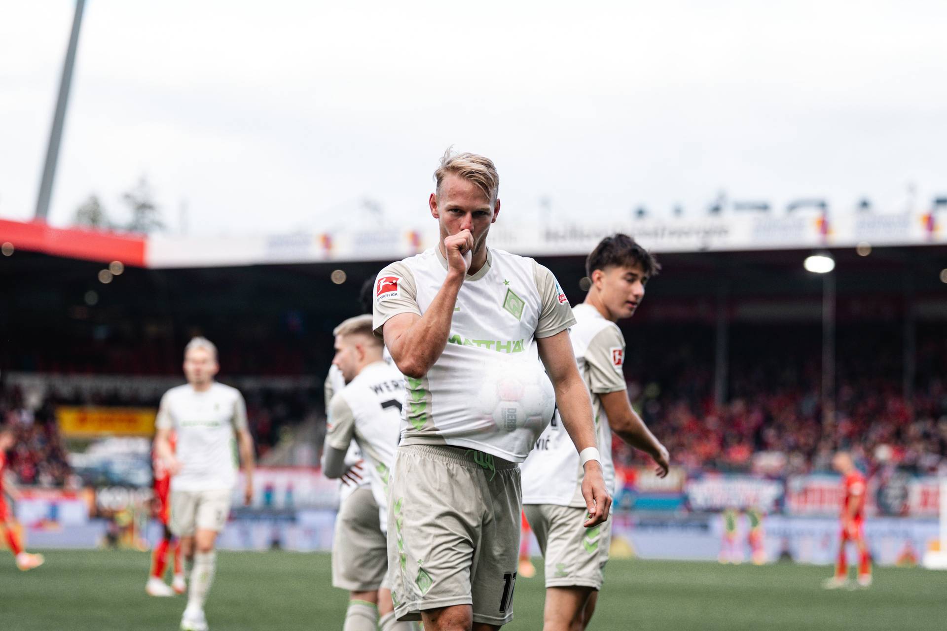 Marco Grüll mit dem Daumen im Mund und dem Spielball unter dem Trikot.