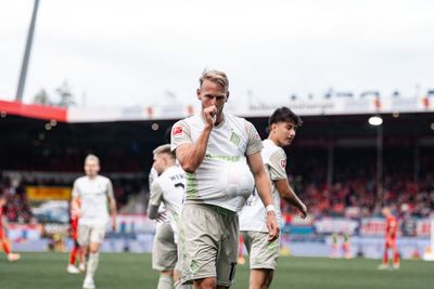 Marco Grüll mit dem Daumen im Mund und dem Spielball unter dem Trikot.