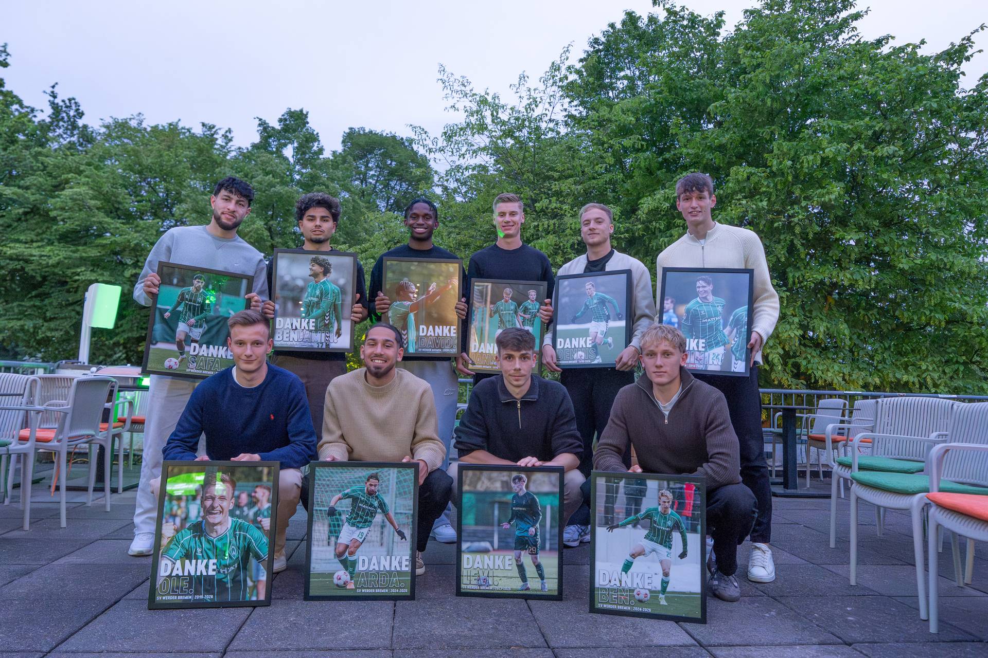 Die verabschiedeten Spieler der U23 stehen zusammen und präsentieren jeweils ein Bild mit ihrer Abschiedsgrafik.