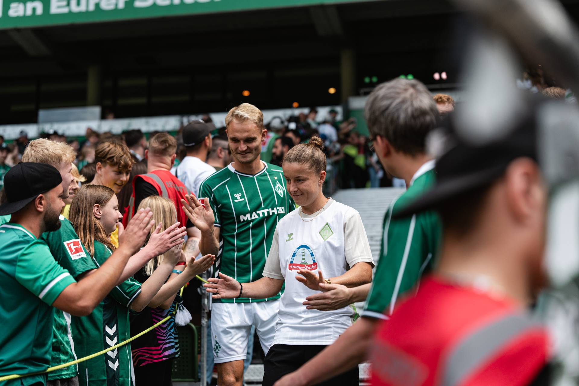 Amos Pieper (li.) und Michelle Ulbrich (re.) klatschen Fans im Stadion ab.