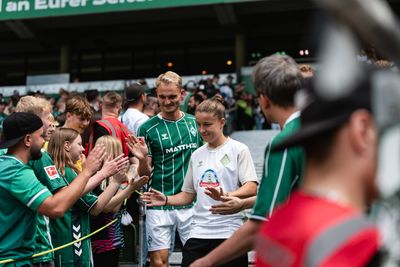 Amos Pieper (li.) und Michelle Ulbrich (re.) klatschen Fans im Stadion ab.