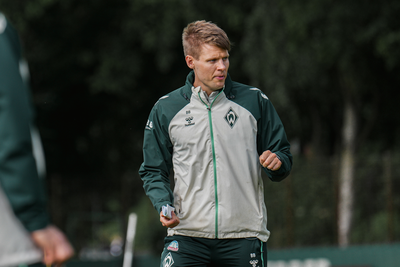 Björn Bremermann steht auf dem Trainingsplatz und gestikuliert.