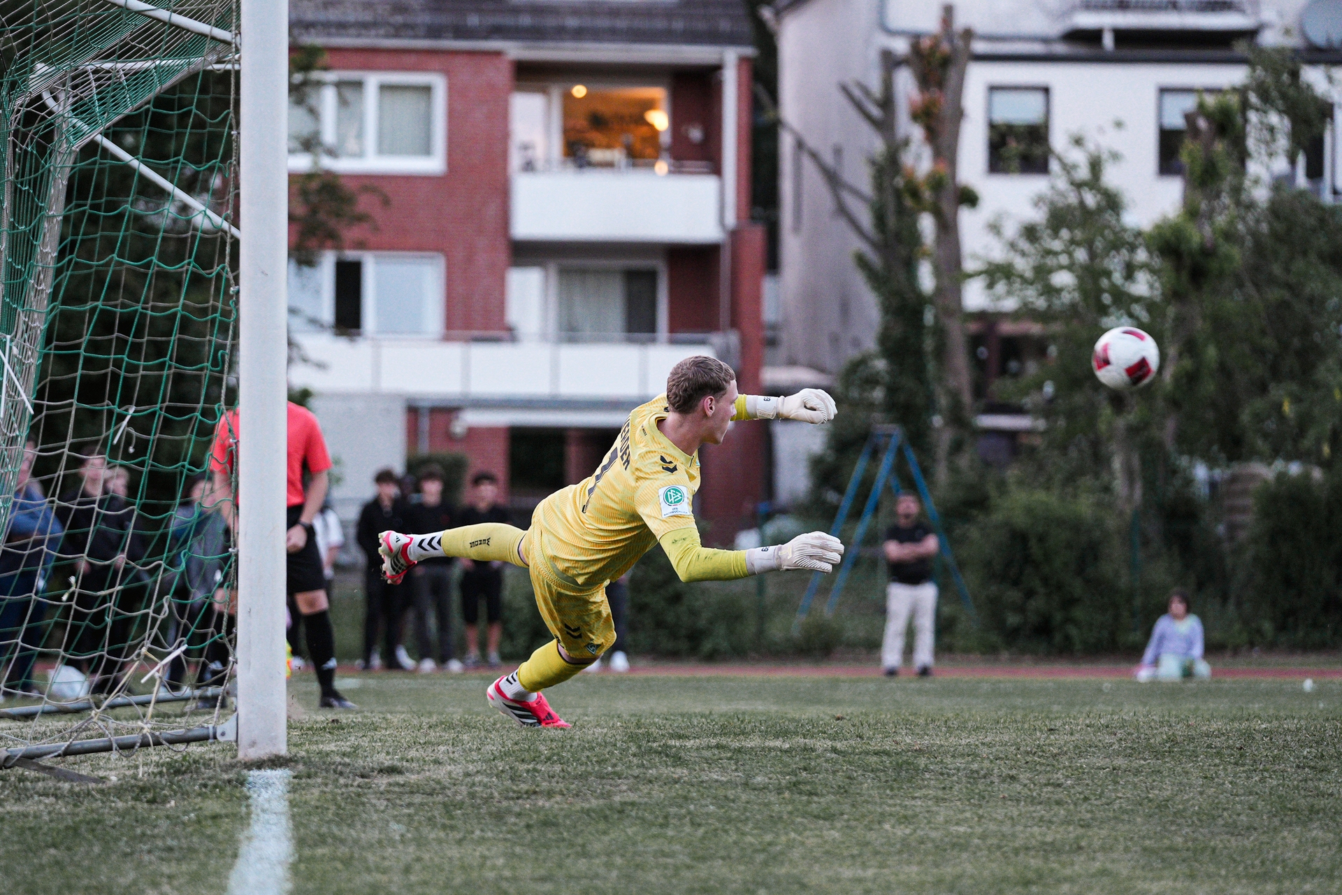Torwart Calvin Seidler springt beim Elfmeterschießen auf einen Ball zu.
