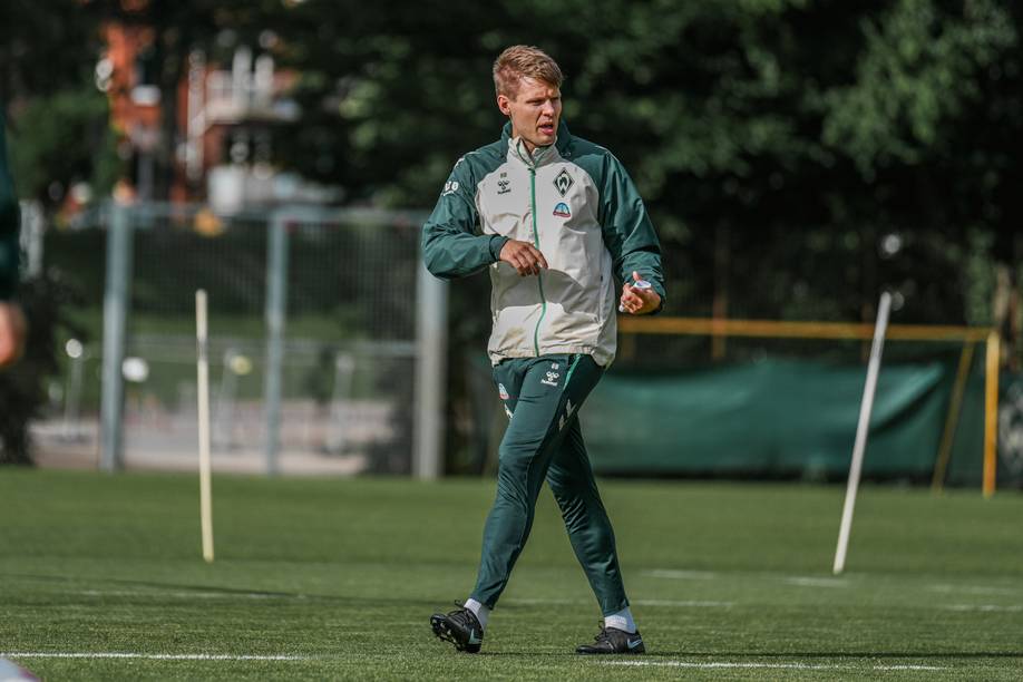 Björn Bremermann auf dem Trainingsplatz. Er erklärt etwas mit seinen Händen.
