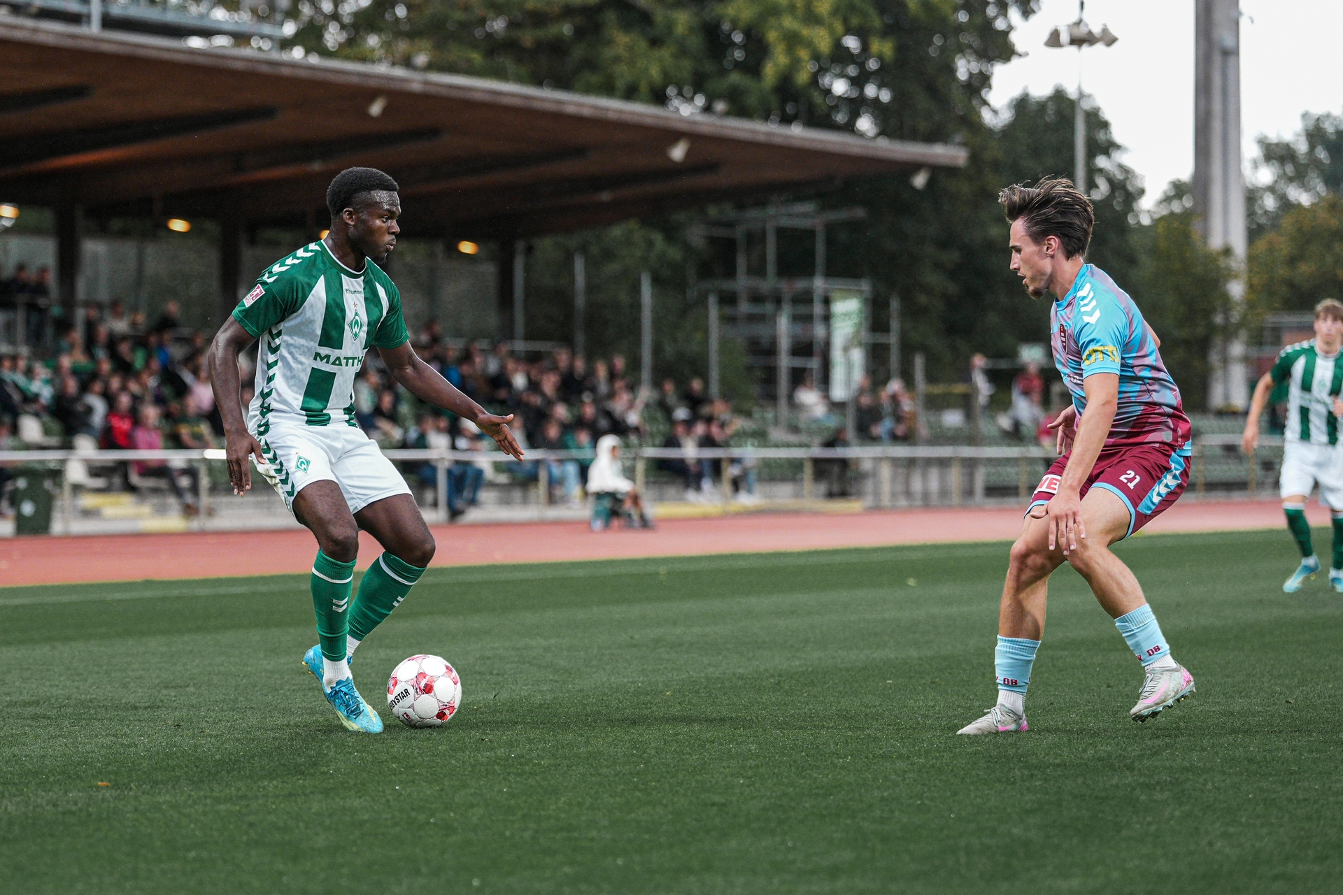 Princewill Mbock dribbelt im Spiel gegen den SC Weiche Flensburg 08 mit dem Ball am Fuß.