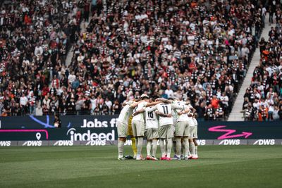 Die Männer-Mannschaft des SV Werder steht zusammen im Kreis. Im Hintergrund ist eine volle Tribüne zu sehen.