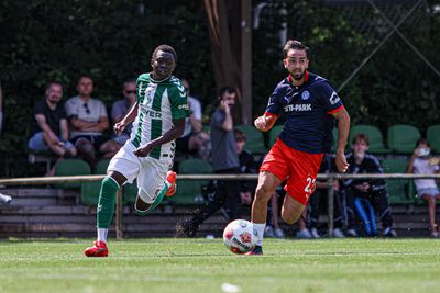 Ein Spieler der U19 läuft mit dem Ball am Fuß und wird von seinen Gegenspielern verfolgt.