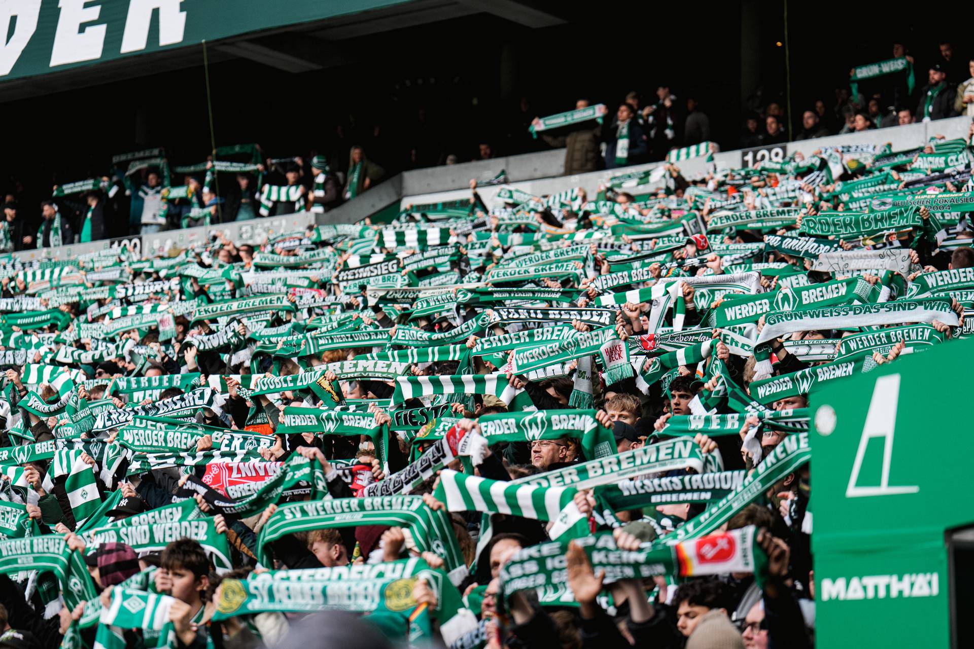 Die Werder-Fans halten ihren grün-weißen Schals in die Höhe.