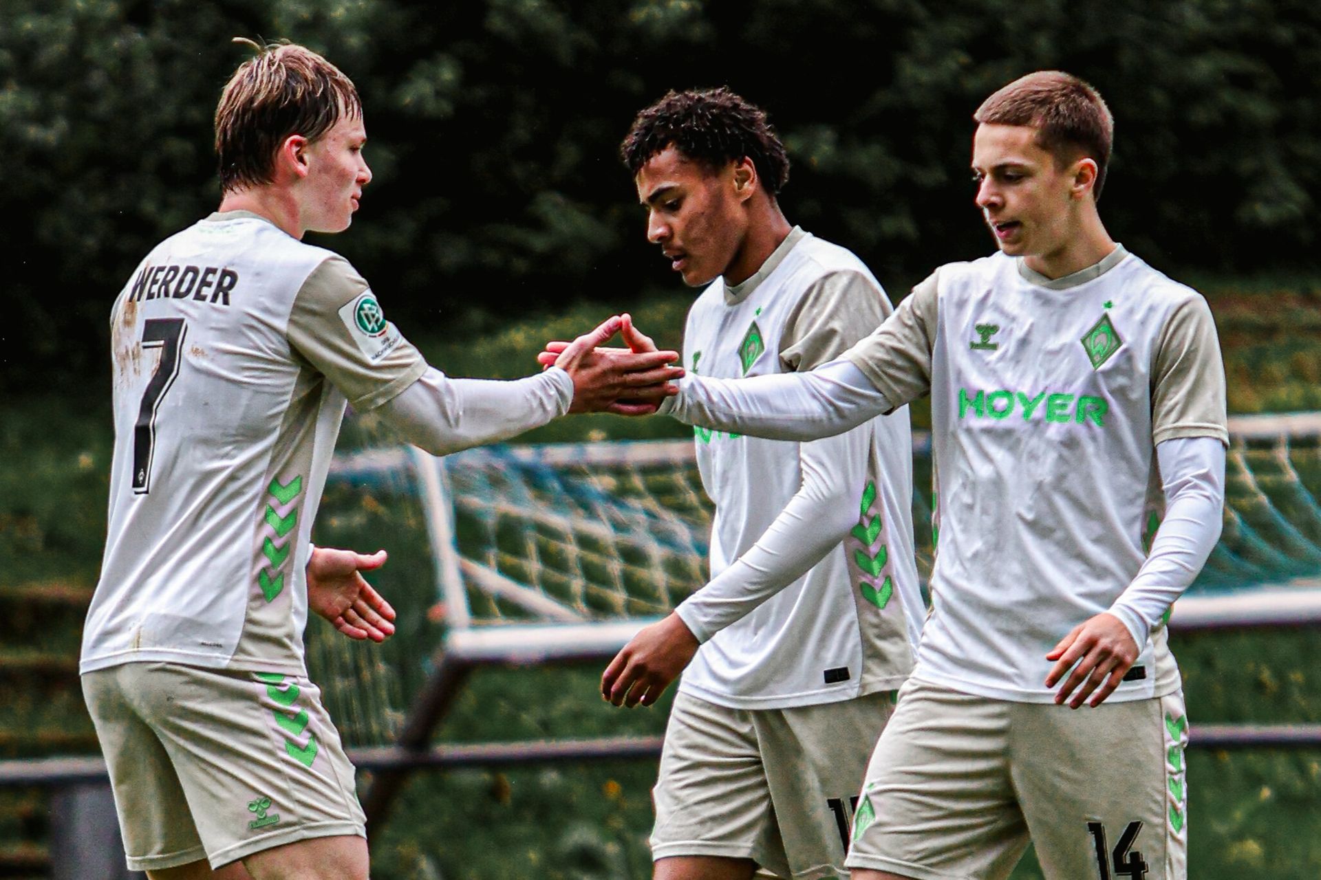 Drei Spieler der U19 klatschen sich ab.