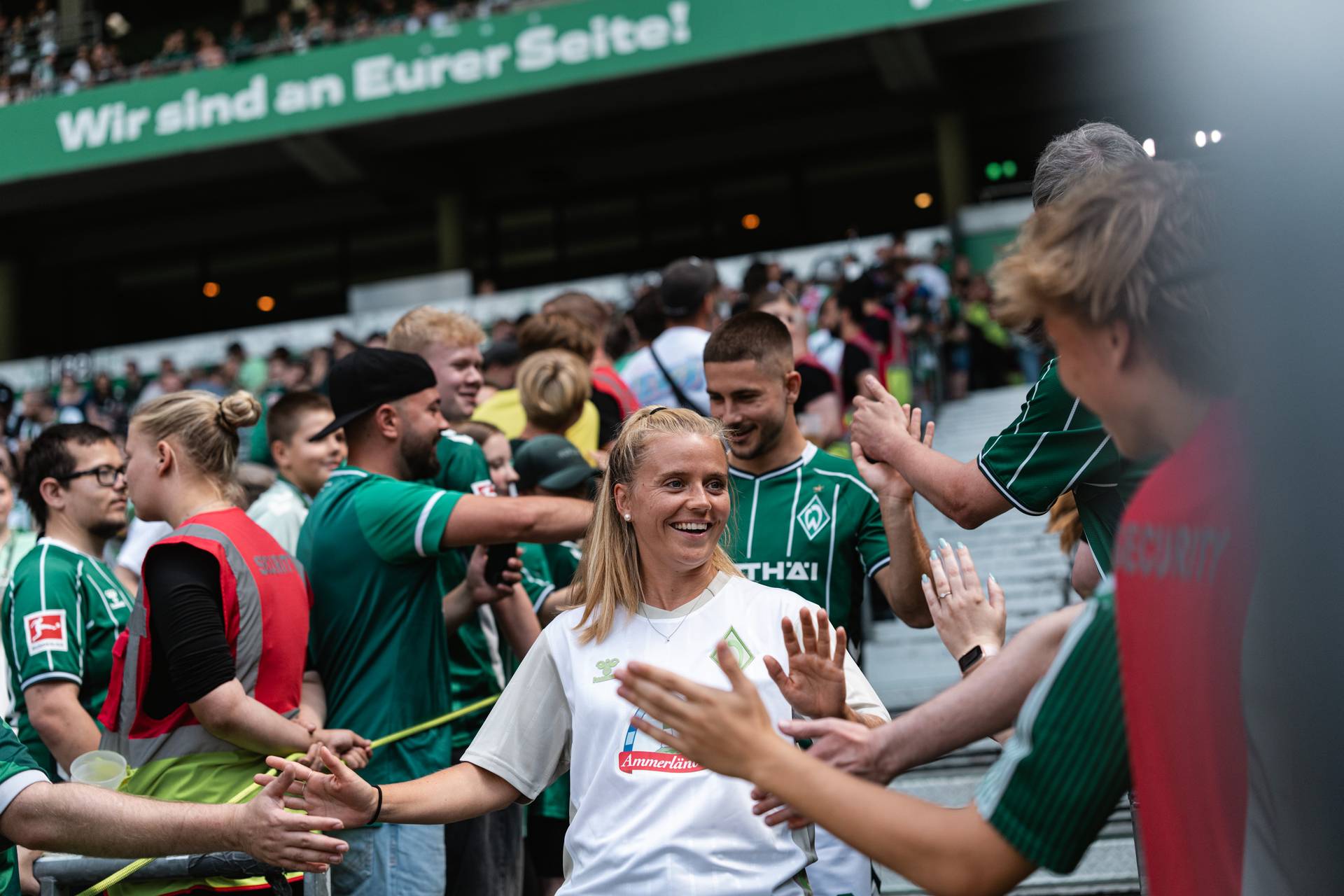 Ricarda Walkling läuft im Weserstadion ein und klatscht bei Fans ab.