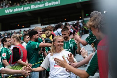 Ricarda Walkling läuft im Weserstadion ein und klatscht bei Fans ab.