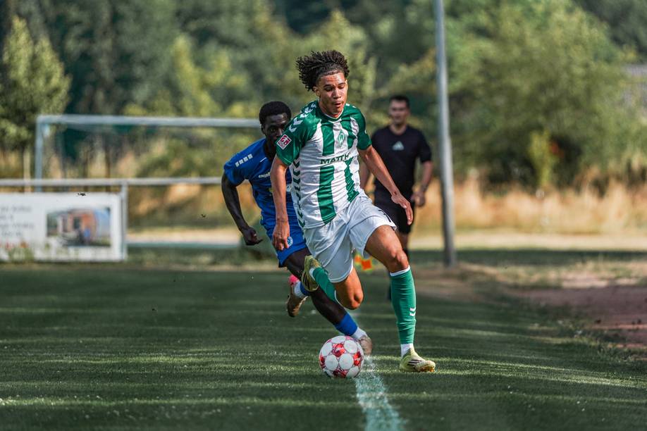 Jasha Barry läuft mit dem Ball und wird von einem Gegenspieler verfolgt.