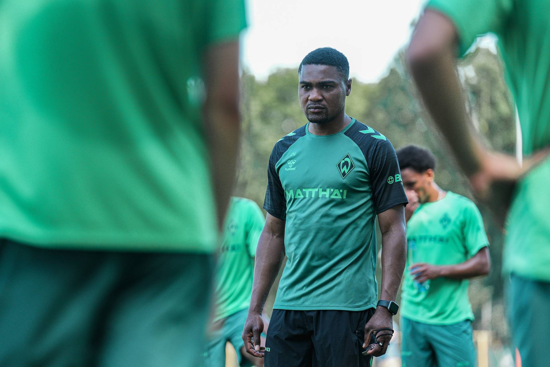 Cédric Makiadi steht auf dem Trainingsplatz und wird von Mitspielern umringt.