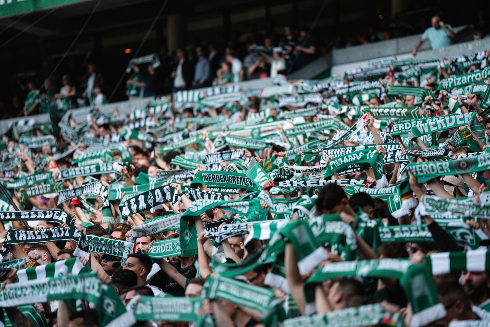 Werderfans halten Schal im Stadion hoch.