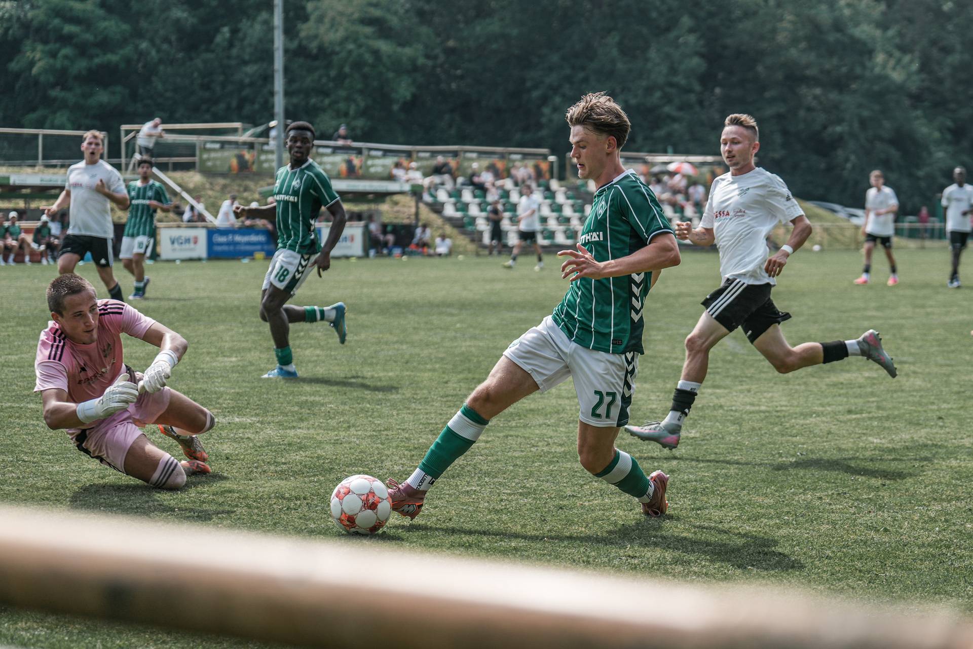 Jannes Ossadnik läuft mit dem Ball, während der Torwart vor ihm in der Luft fliegt.