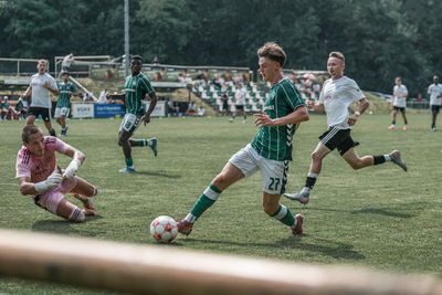 Jannes Ossadnik läuft mit dem Ball, während der Torwart vor ihm in der Luft fliegt.