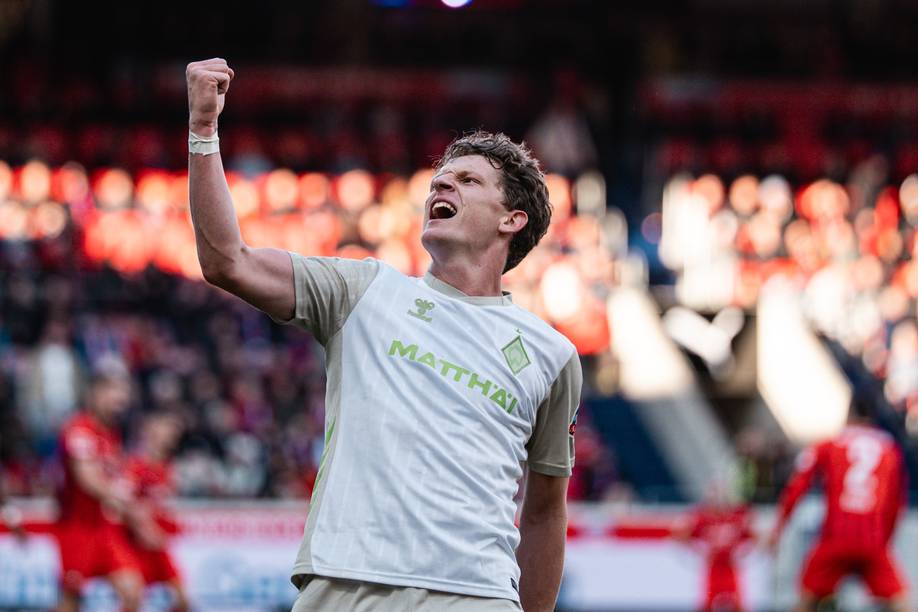 Jens Stage im weißen Trikot schreit und streckt eine Faust in die Luft.