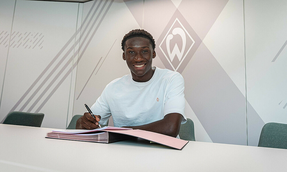 Coulibaly unterschreibt seinen ersten Profivertrag. 