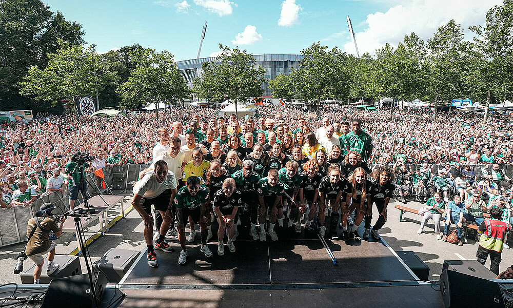 Die Mannschaften auf der Bühne vor der Crowd. 
