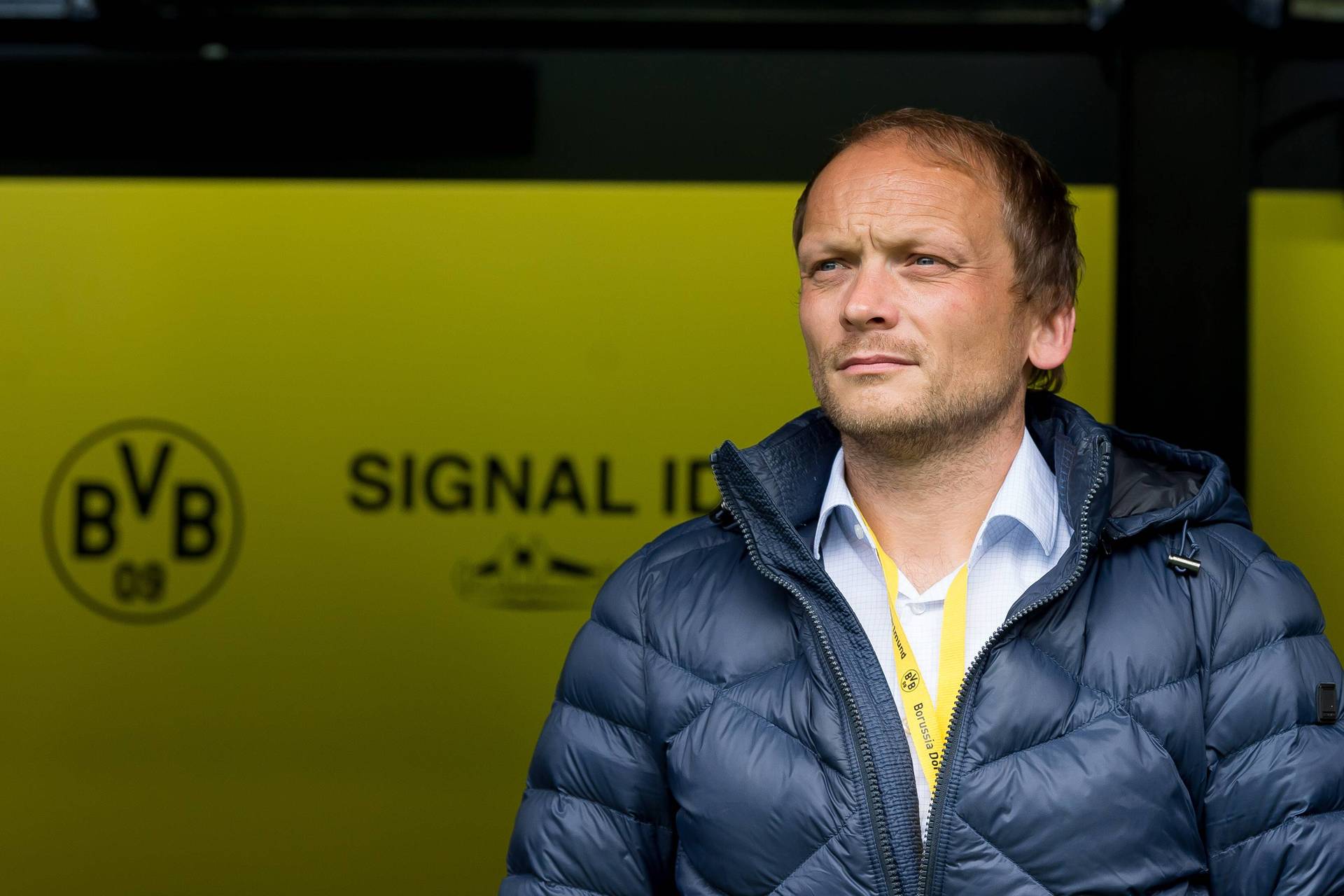 Ein Foto von Markus Pilawa, im Hintergrund ein Logo von Borussia Dortmund.