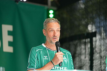 null Tarek Brauer im Werder-Heimtrikot am Mikro.