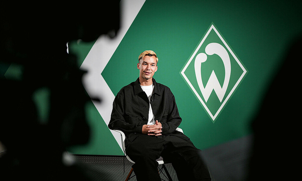 Mio Backhaus erzählt im Interview. Eine Kamera ist auf ihn gerochtet. 