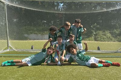 Jungs, die im Werder-Trikot in einem Tor stehen und jubeln