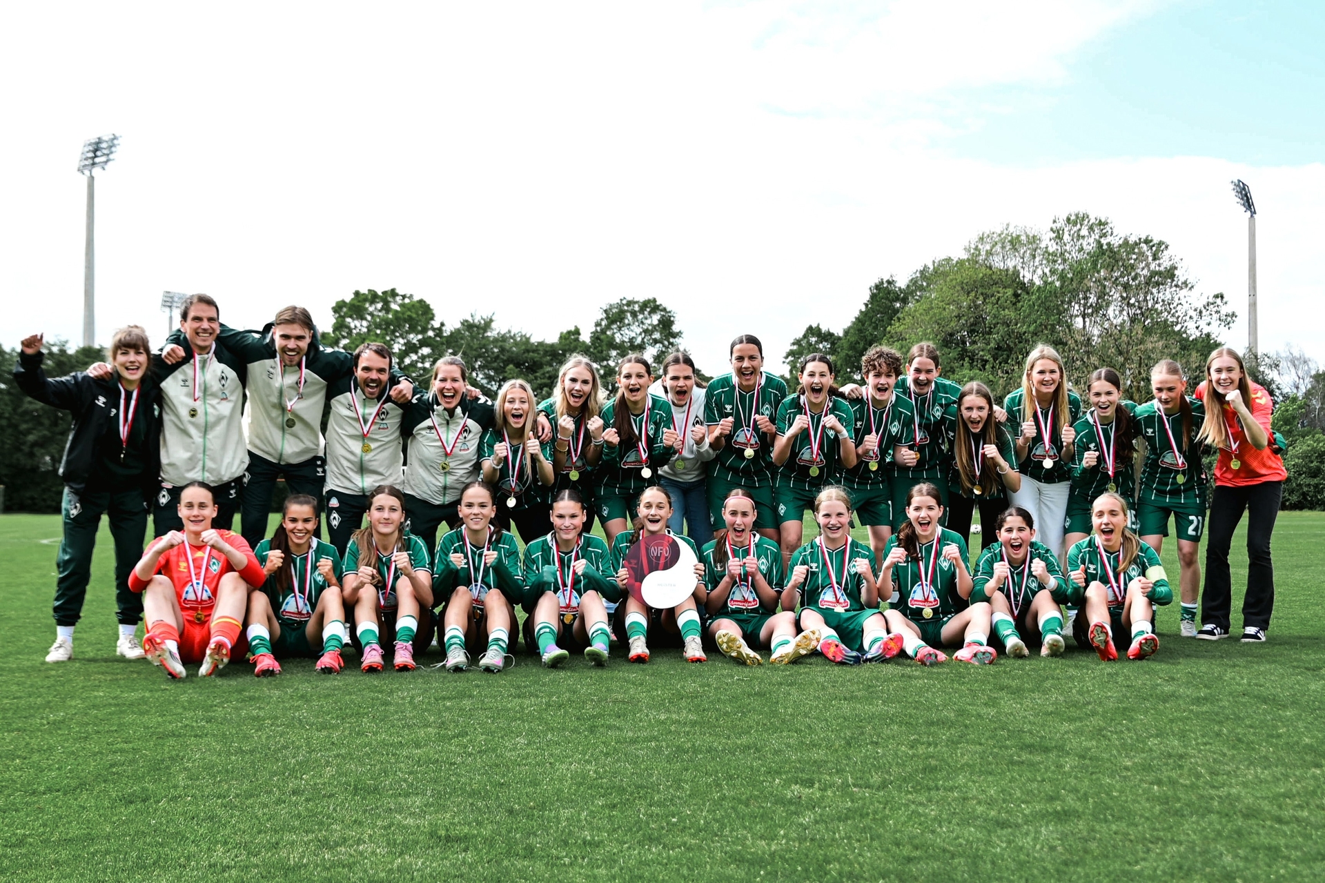 Die U17-Juniorinnen im grünen Dress jubeln auf dem Mannschaftsfoto nach dem Sieg der Meisterschaft.
