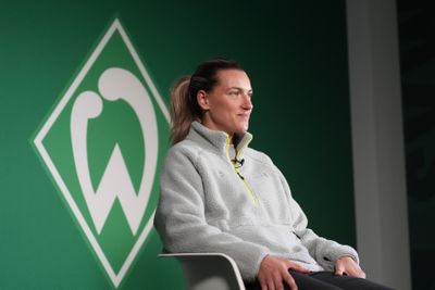 Medina Desic sitzt auf einem Stuhl und lächelt.