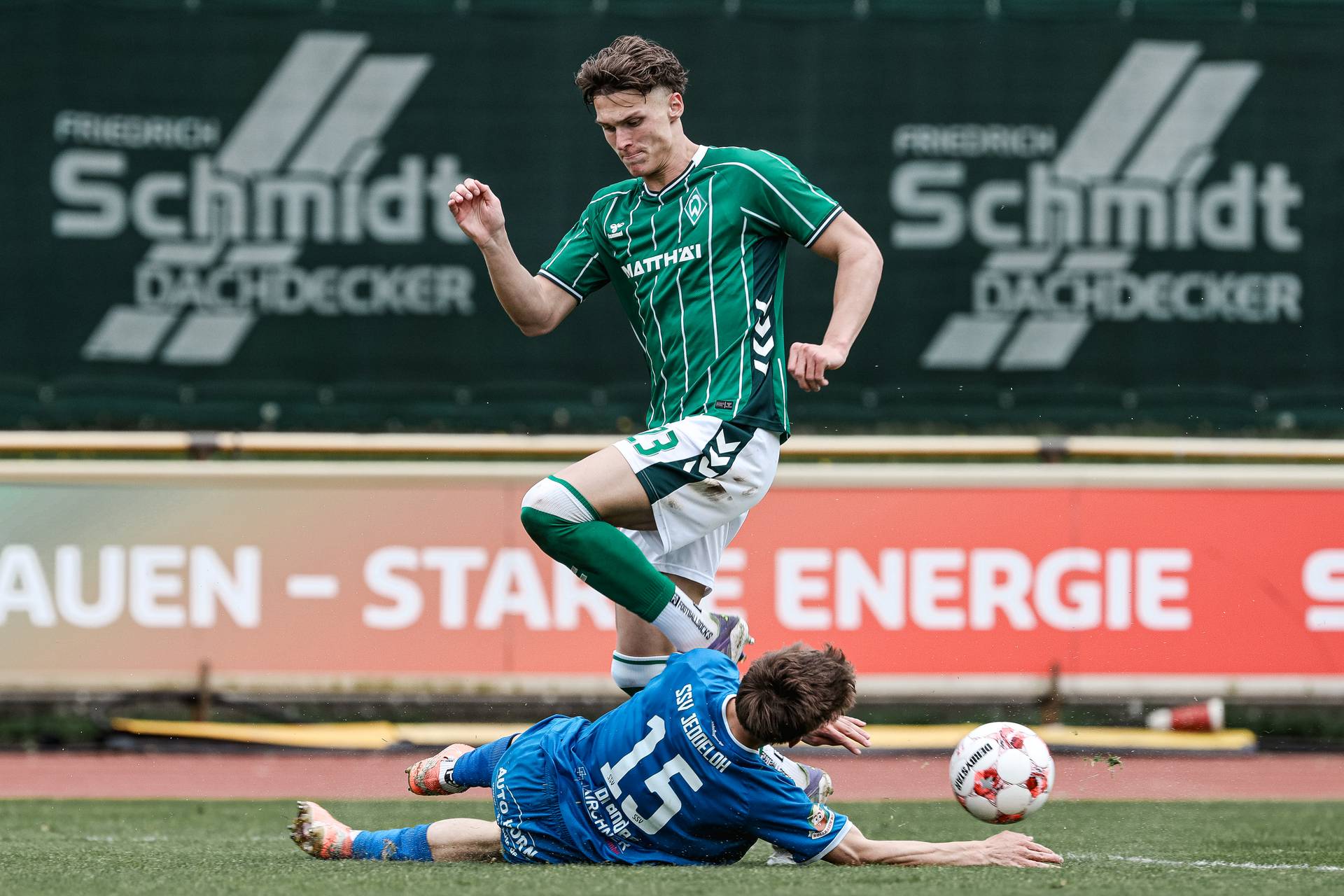 Kevin Manthey läuft mit dem Ball, während ein Gegenspieler vor ihm grätscht.