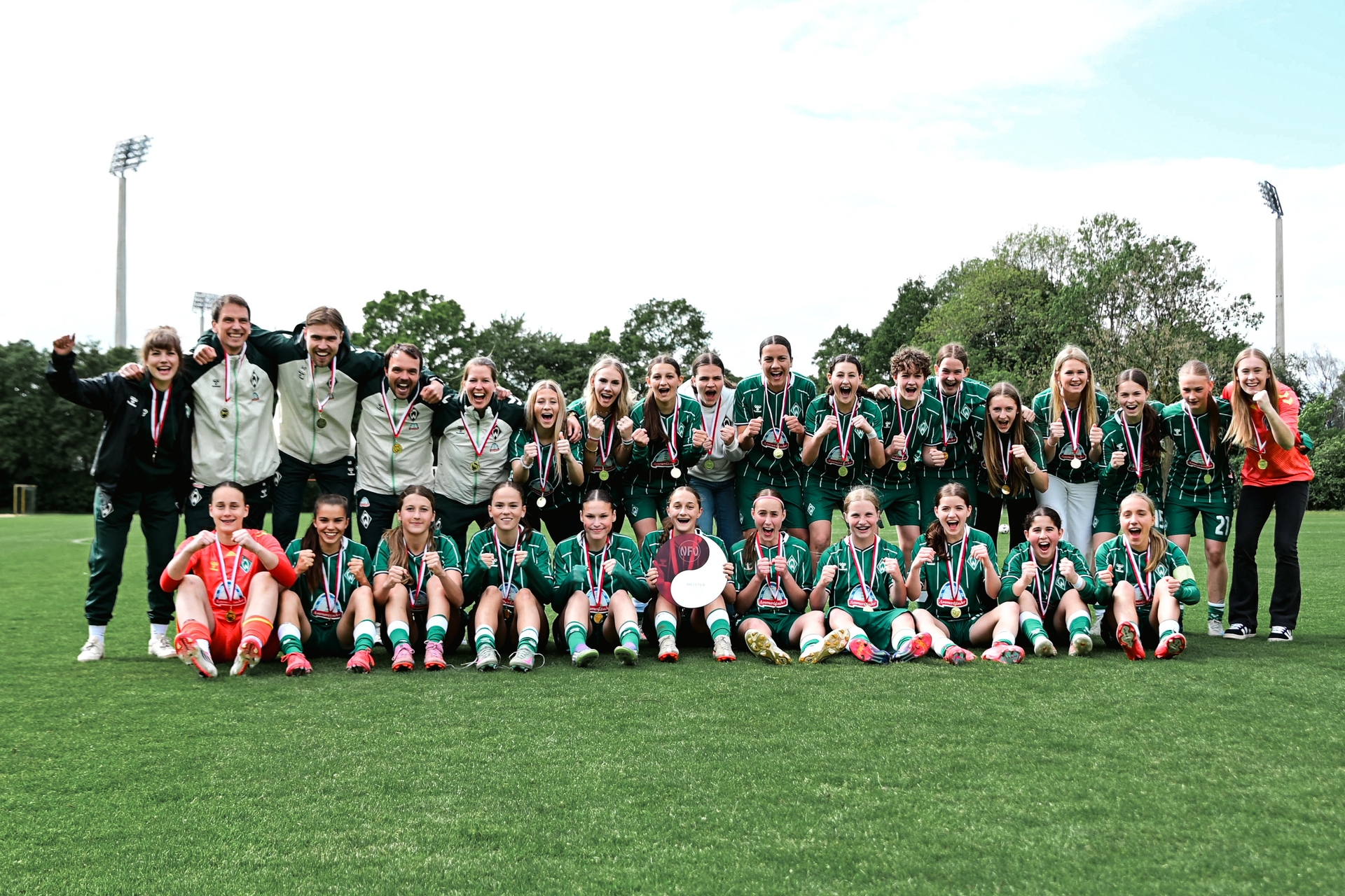 Die U17 jubelt nach der gewonnenen Meisterschaft mit Medaillen und Meisterschale in die Kamera