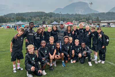 Die U11 steht gemeinsam mit Marco Friedl und blickt in die Kamera.