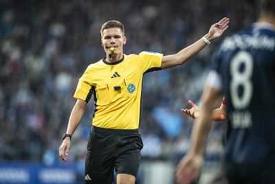 Schiedsrichter Dr. Florian Exner mit der Pfeife im Mund.