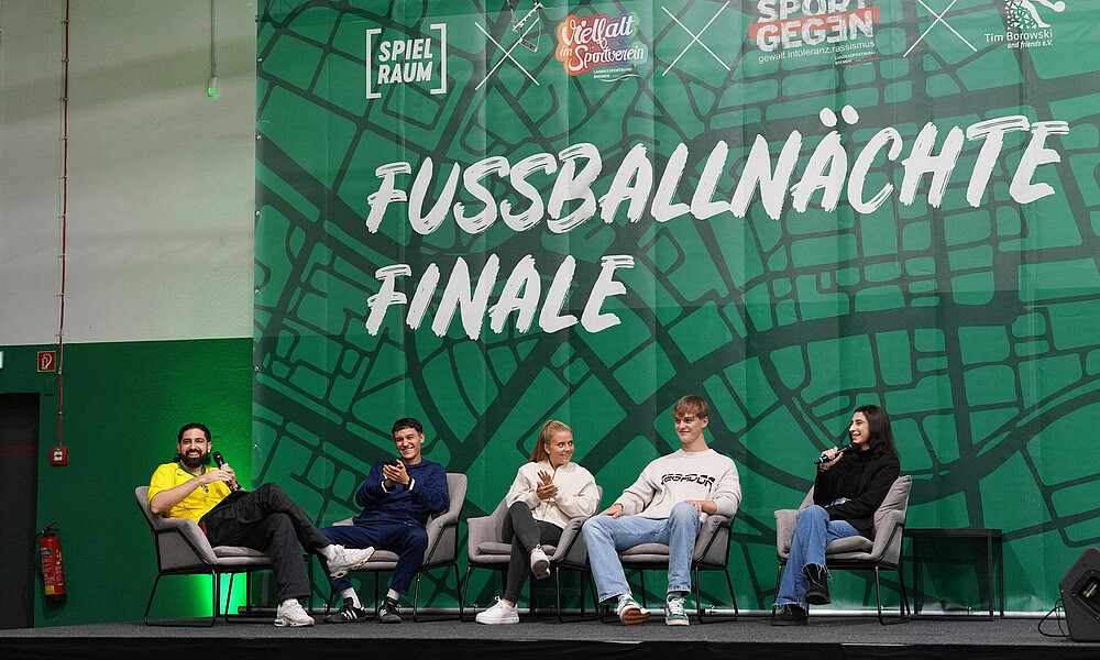 U.a. Mats Heitmann und Ricarda Walkling sitzen auf einem Podest und nehmen an einer Podiumsdiskussion teil.