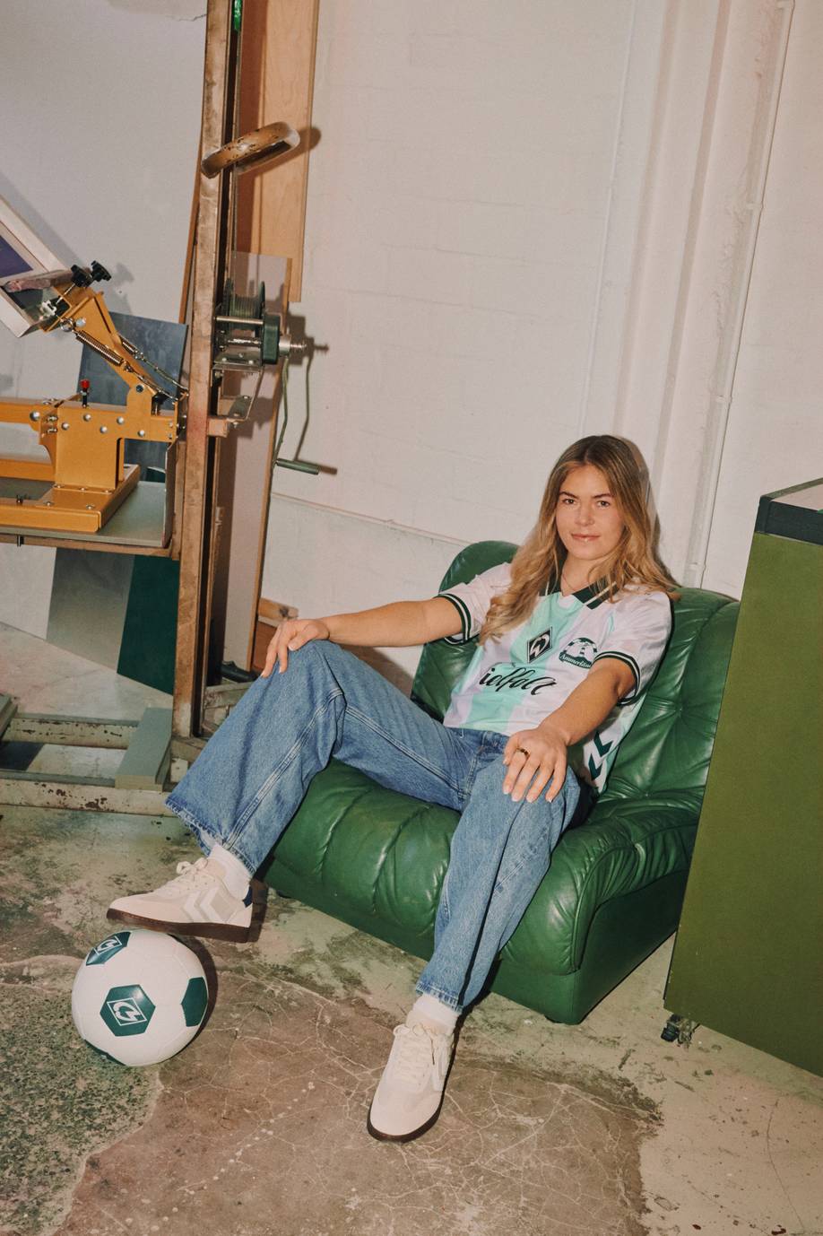 Juliane Wirtz sitzt im Werder-Vielfaltstrikot in einem Sessel.