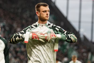 Karl Hein zieht sich den Handschuh aus.