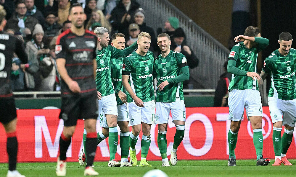 null Marco Grüll wird von seinen Teamkollegen umarmt.