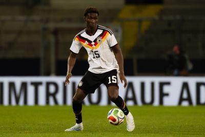 Karim Coulibaly im DFB-Trikot. Er hat den Ball vor sich und schaut nach einer Anspielstation.