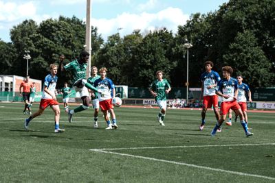 Neal Afriyie spielt den Ball in der Ball Luft und ist umringt von Gegenspielern.