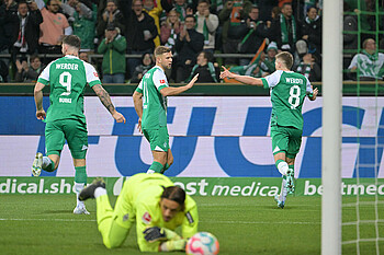 Mitchell Weiser läuft jubelnd zu Niclas Füllkrug. Im Vordergrund unscharf Gladbachs Keeper.