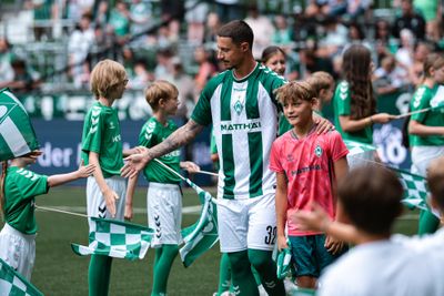 Marco Friedl klatscht Kindern ab und läuft ins Weserstadion ein.